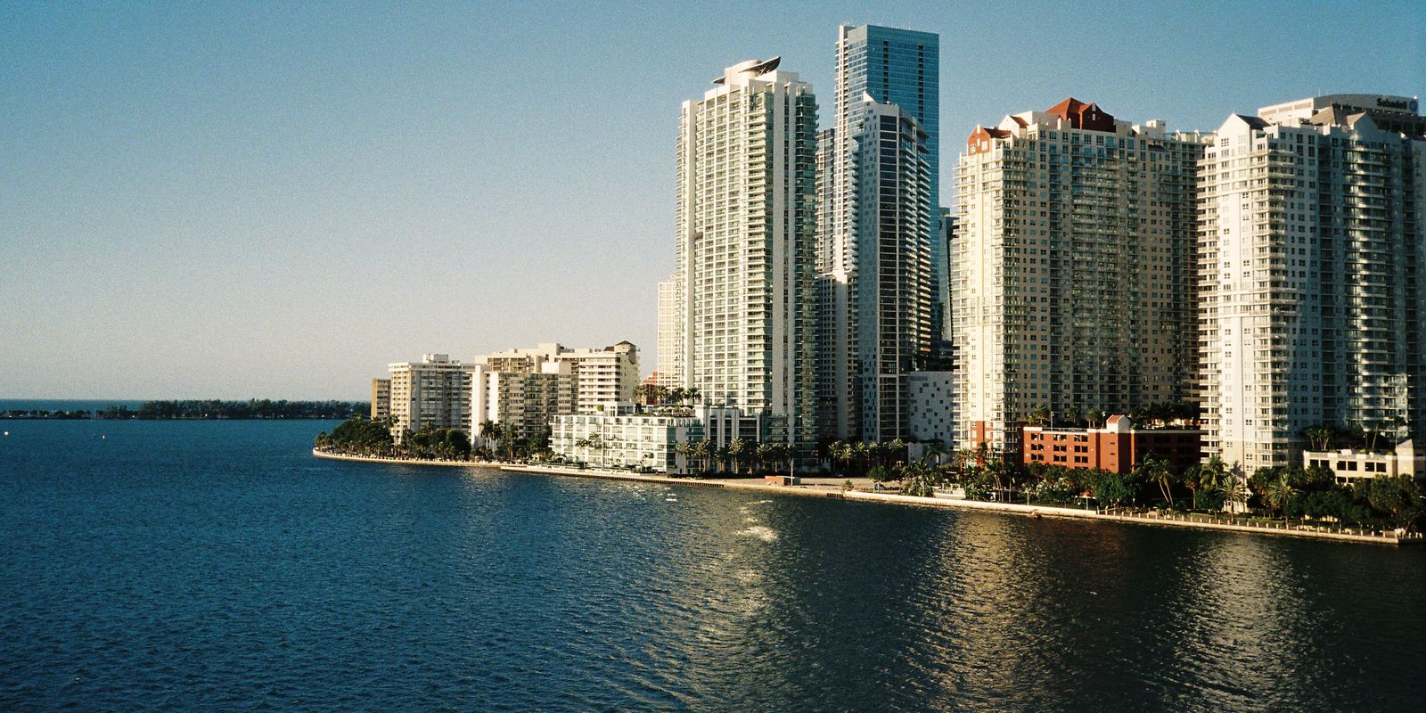 Torres residenciales junto al agua en Miami, con la luz de la tarde y la bahía de Biscayne en primer plano.