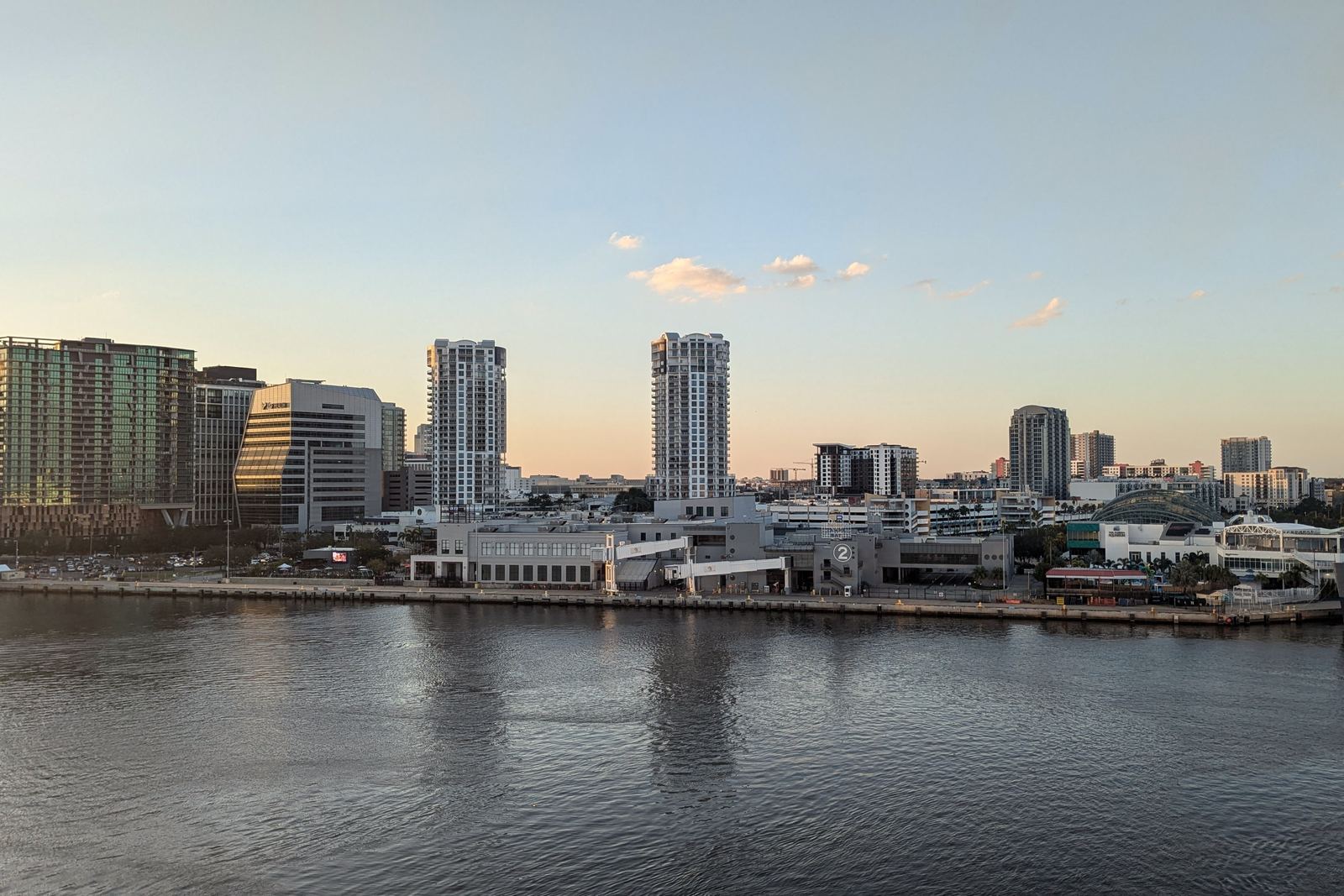 Tampa across the water at sundown, its towers lit by the last sun.